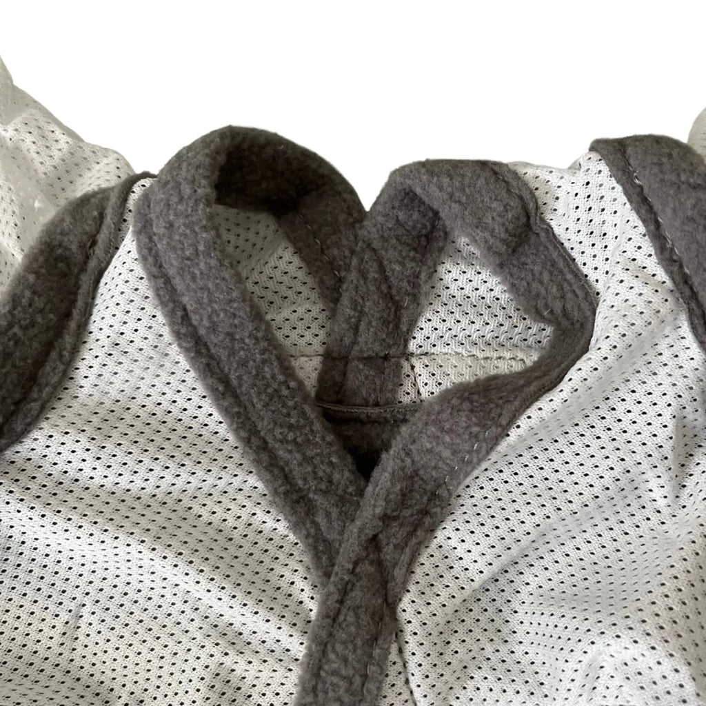 Detail einer weißen Fliegenmaske für Pferde mit grauem Fleece-Rand und atmungsaktivem Netzstoff